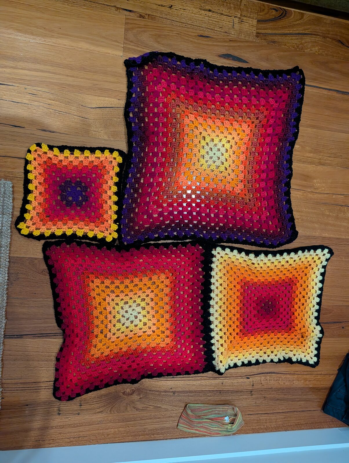 Crocheted granny squares in the Apricity palette: red, orange, gold and purple